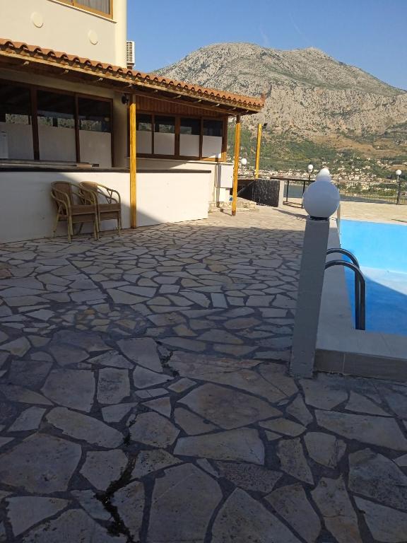 eine Terrasse mit Pool und ein Haus in der Unterkunft Golden village in Astakós
