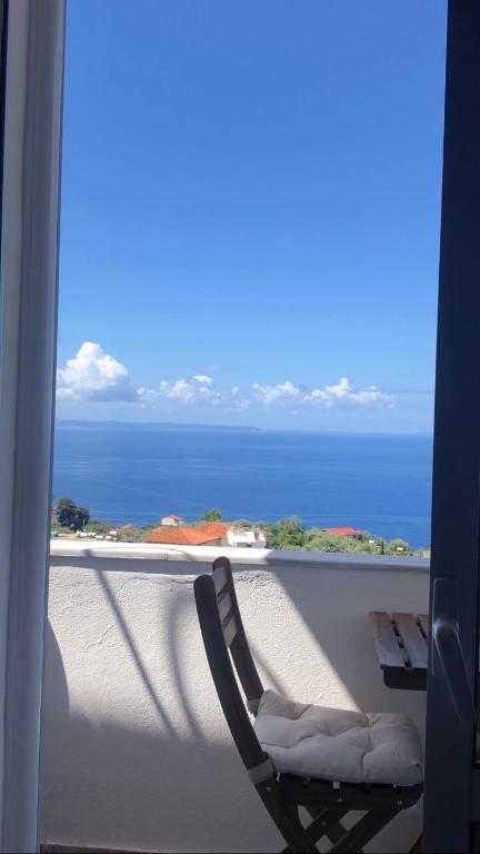 a chair on a balcony with a view of the ocean at Blue Paradise Apartment in Lukovë
