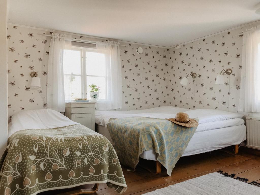 a bedroom with two beds and a window at Bull-August gård vandrarhem/hostel in Arholma