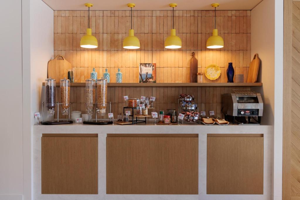 a kitchen with a counter with two lights above it at Hilton Garden Inn Marseille Provence Airport in Marignane