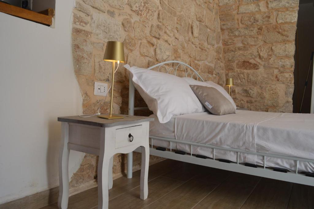 1 dormitorio con 1 cama y 1 mesa con lámpara en Geometric Donna Giulia en Casamassima