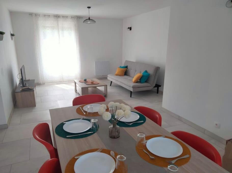 a dining room with a table and red chairs at Jolie maison rénovée avec espace vert in Thonnance-lès-Joinville