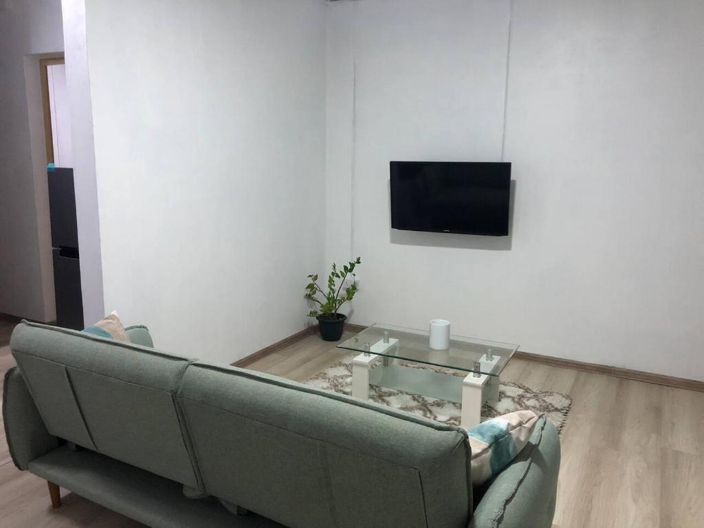 a living room with a couch and a tv on a wall at stevenhome in Quatre Bornes