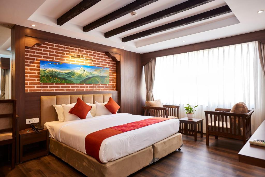 1 dormitorio con cama y pared de ladrillo en Kantipur Village, en Katmandú