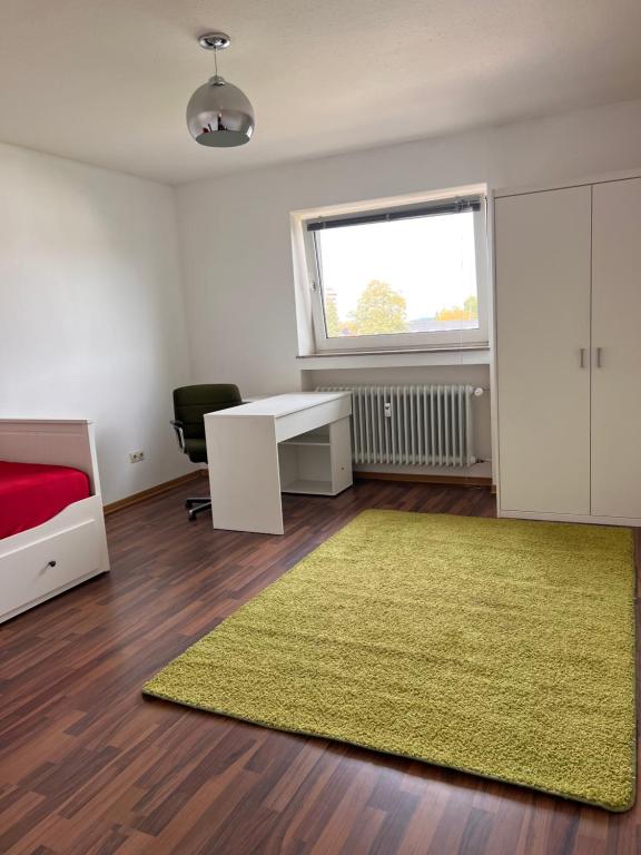 a room with a bed and a desk and a green rug at Gäste, Handwerker Zimmer - 2 Betten in Rosenfeld