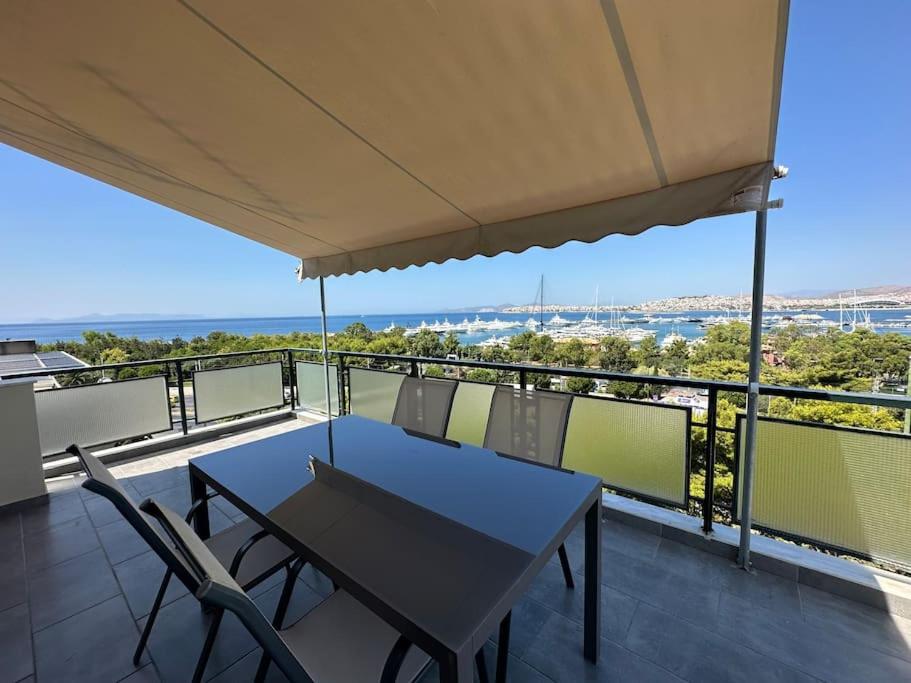 a table and chairs on a balcony with a view at Floisvos Penthouse Oasis in Athens