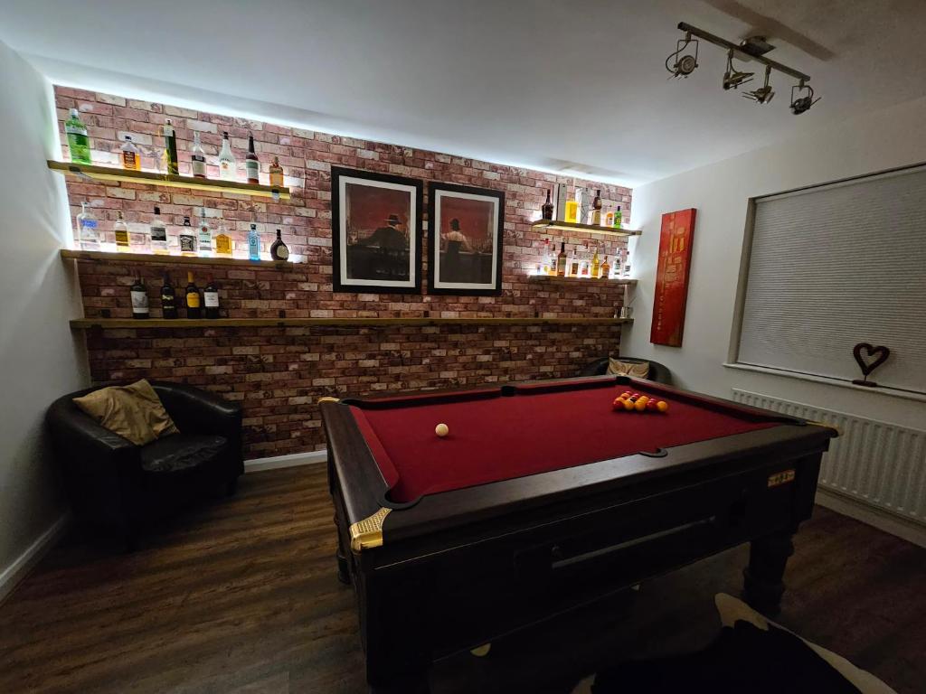 a room with a pool table and a brick wall at Executive Lakeside 4 Bed Townhouse in Simpson