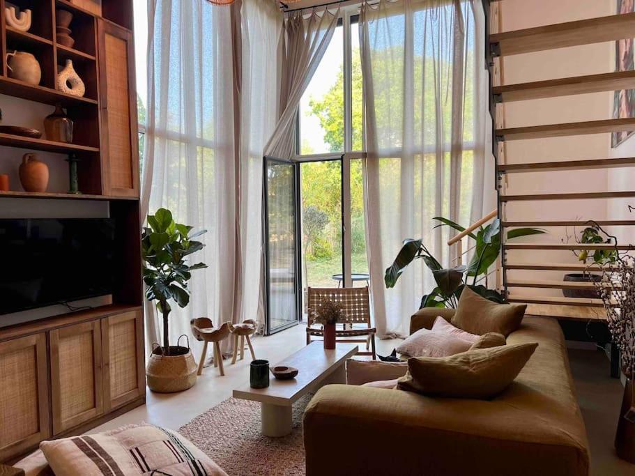 un salon avec un canapé et une grande fenêtre dans l'établissement 3 bedroom Duplex with garden, à Marseille