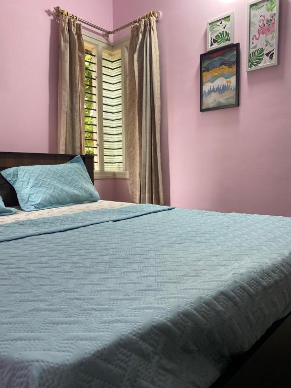 邁索爾的住宿－Spacious 3 Queen Bed Suite 6 km to Palace With Farm Land and Hill View，一间卧室配有一张粉红色的墙壁和窗户。