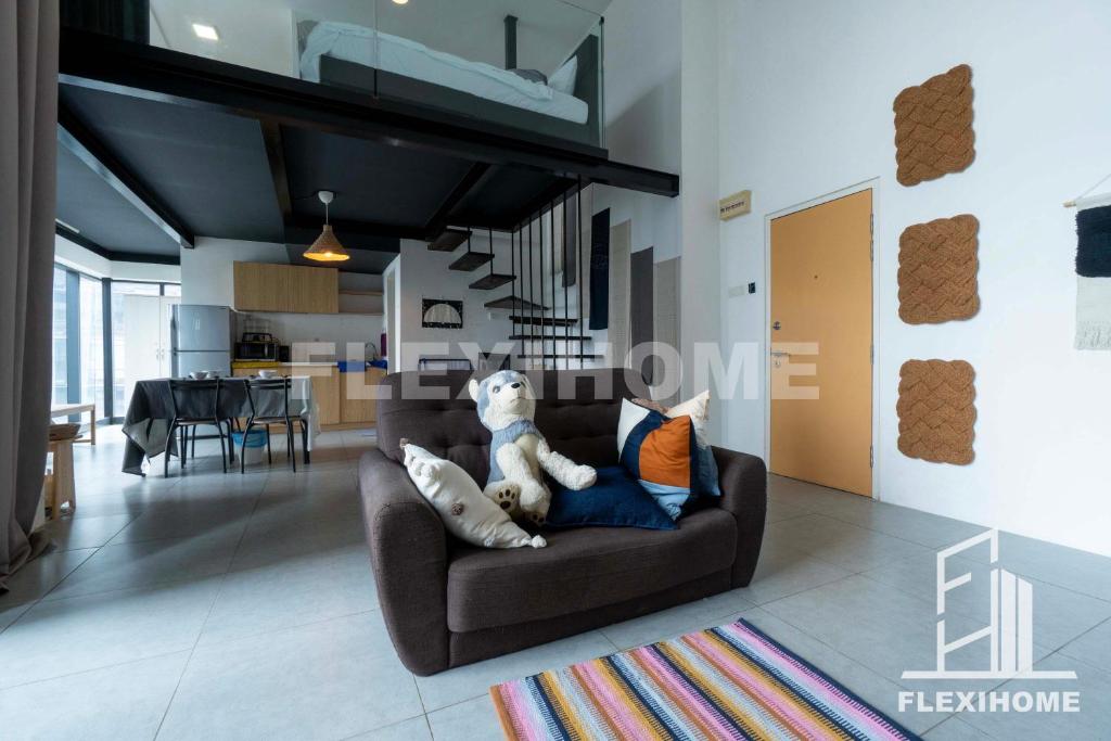 a teddy bear sitting on a couch in a living room at 1-5 Guests, Spacious & Comfy Duplex-Studio, Empire City Damansara by Flexihome-MY in Petaling Jaya