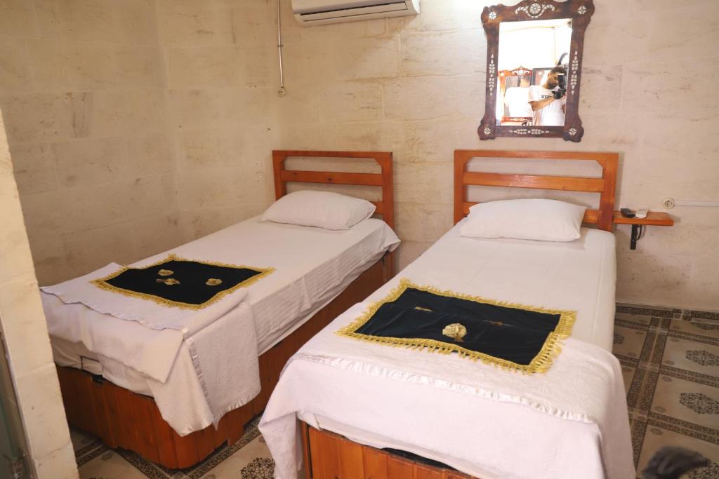 two beds in a room with a mirror at LÜTFÜ BEY KONAĞI in Şahinbey