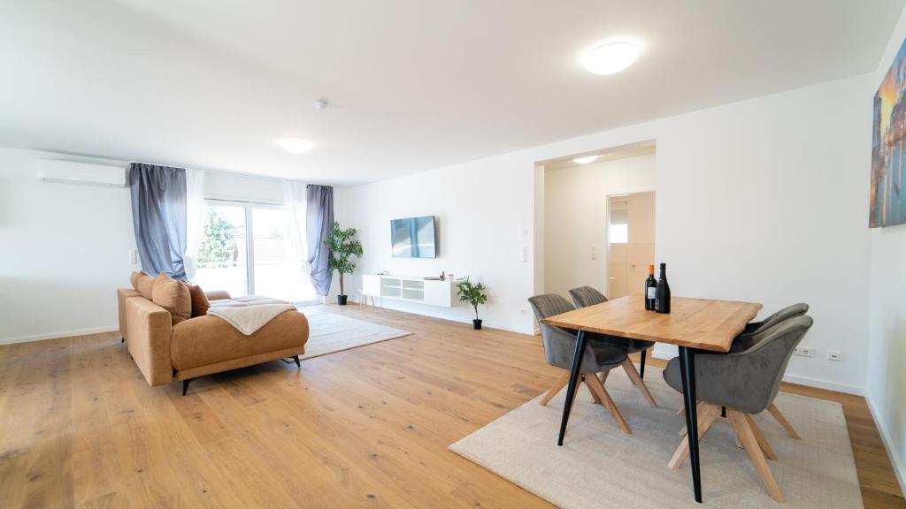 sala de estar con mesa y sofá en Apartments by KEN, en Ramstein-Miesenbach