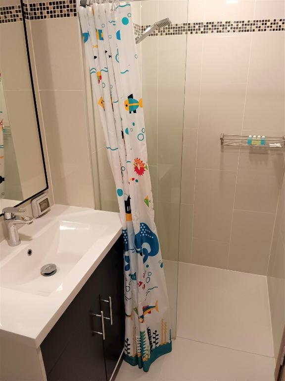 a bathroom with a shower curtain with a sink at Laguna Beach Resort 3 Maldives in Jomtien Beach