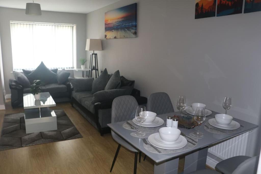 a living room with a table and a couch at Coleridge house Private parking NETFLIX in Swindon