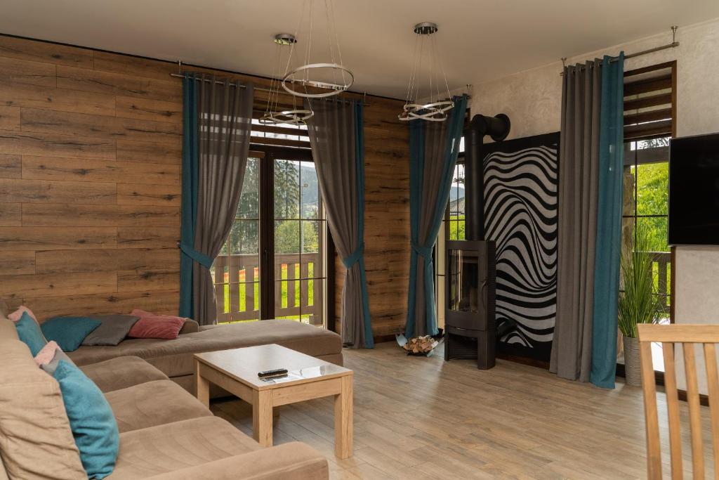 a living room with a couch and a table at CHALET NEBO in Bukovel