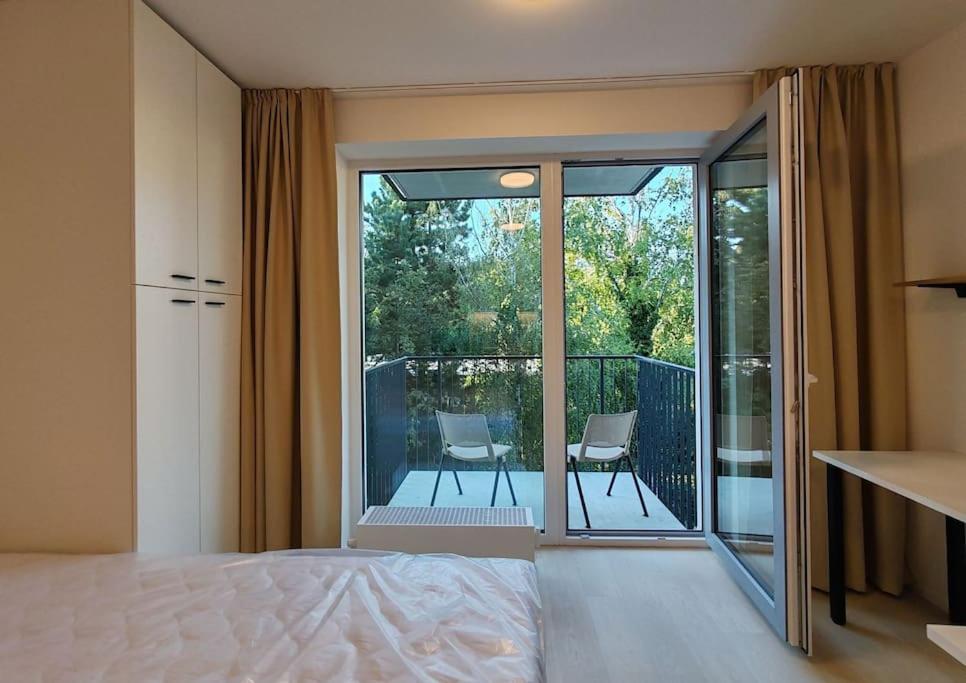 una camera con letto e un balcone con sedie di A Star Apartment Brno with Terrace a Brno