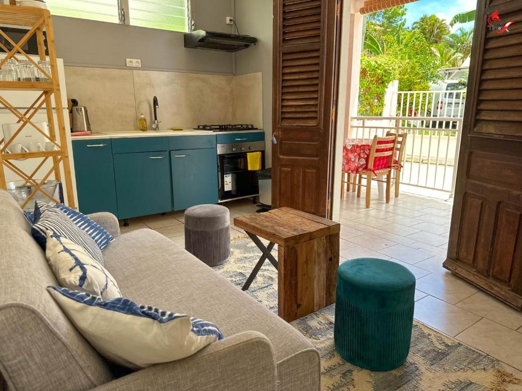 a living room with a couch and a kitchen at Chez Zèlou in Sainte-Anne