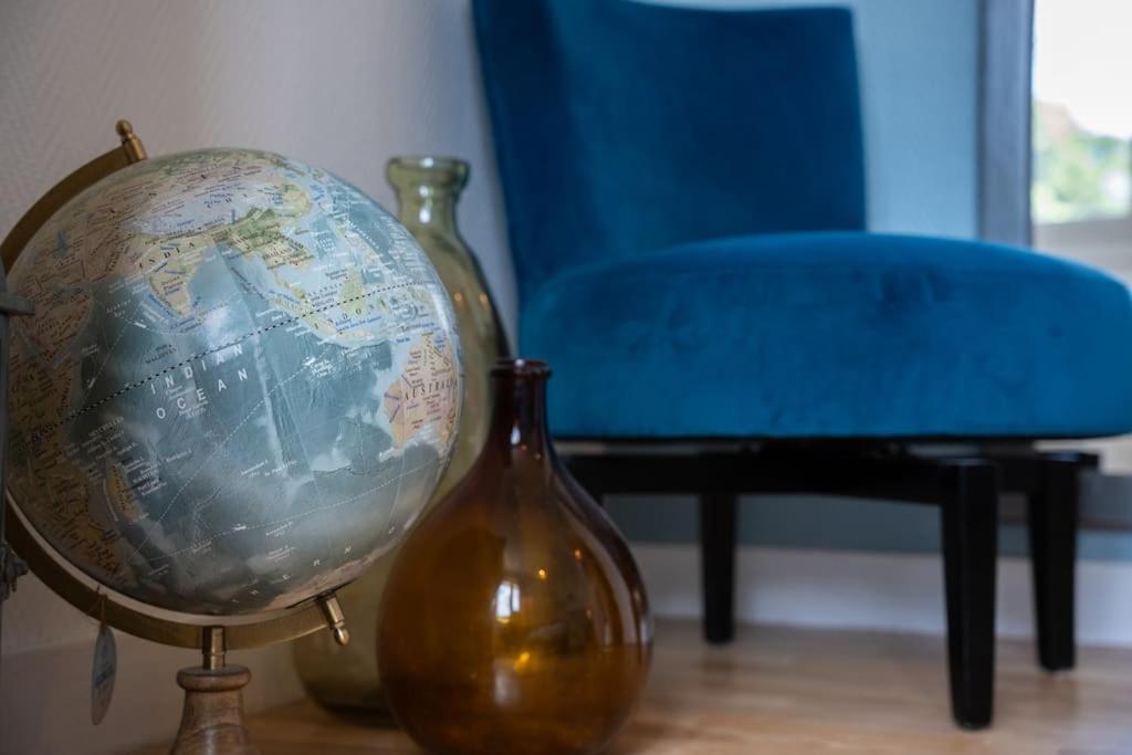 a globe sitting next to two vases and a blue chair at Les Hirondelles By Nid&#39;Ouest in Quimper