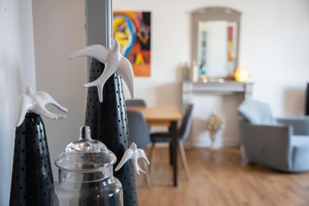 a living room with a table and a vase with birds on it at Les Hirondelles By Nid'Ouest in Quimper