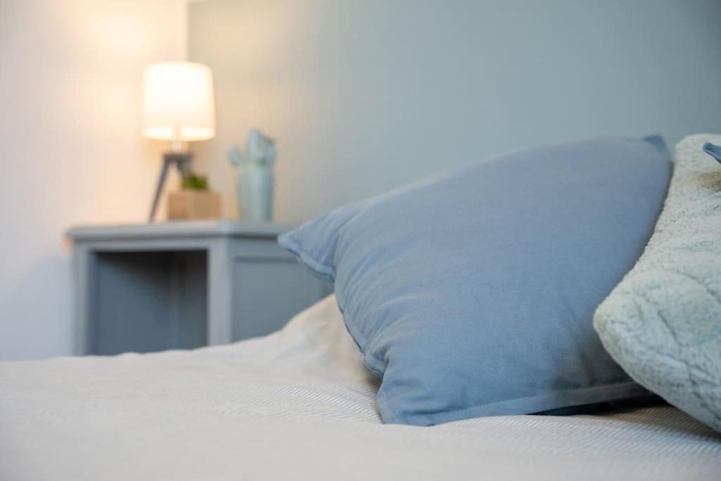 a blue pillow sitting on top of a bed at Les Hirondelles By Nid&#39;Ouest in Quimper