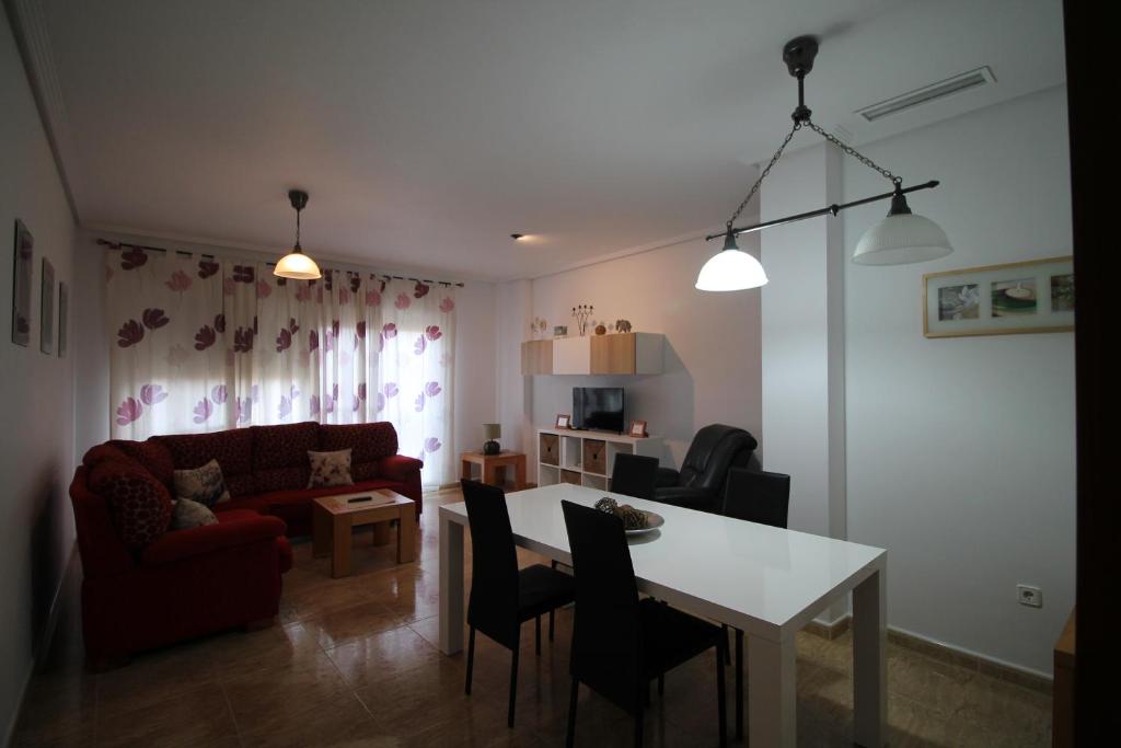 ein Wohnzimmer mit einem roten Sofa und einem Tisch in der Unterkunft Apartamento BENIMUR 3 in Cobatillas