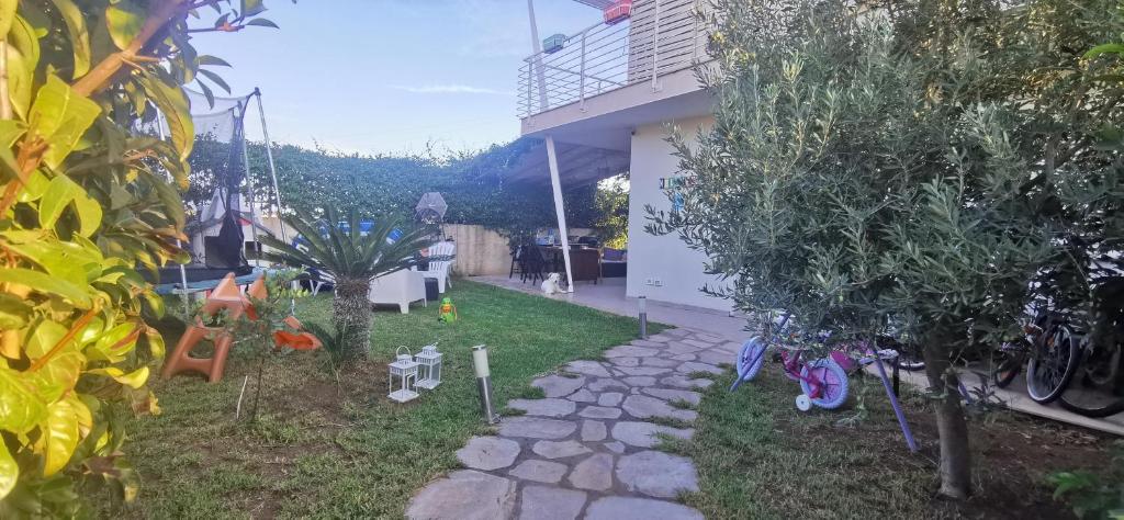 einen Hinterhof mit Bäumen und einem Steinweg in der Unterkunft Villetta Luxury Lunady vicino al mare in Marina di Ragusa