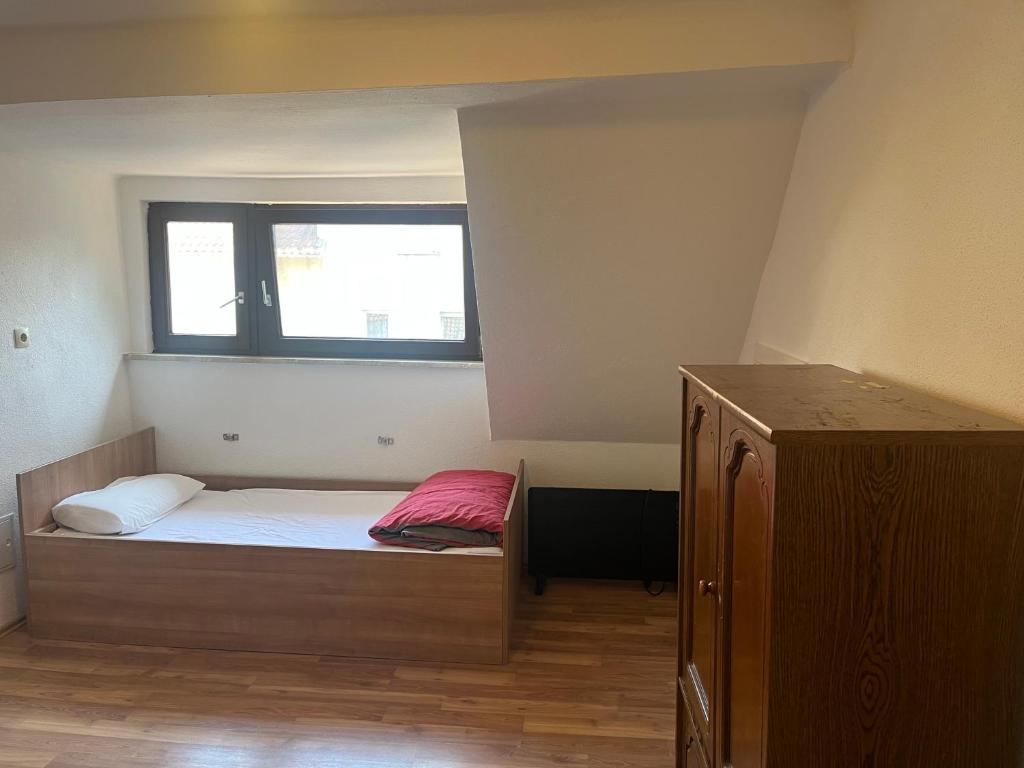 um pequeno quarto com uma cama e uma janela em Rose Gasthaus em Crailsheim