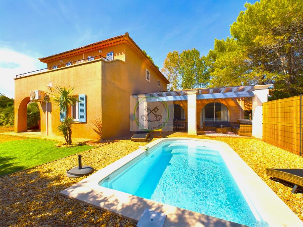 a swimming pool in front of a house at Villa 4 chambres avec piscine in Fréjus
