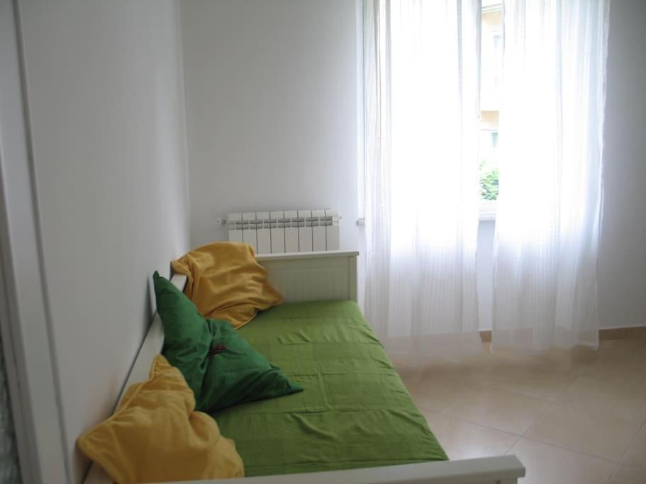 a green couch with two pillows on it in a room at Apartment with private Garden in Finale Ligure