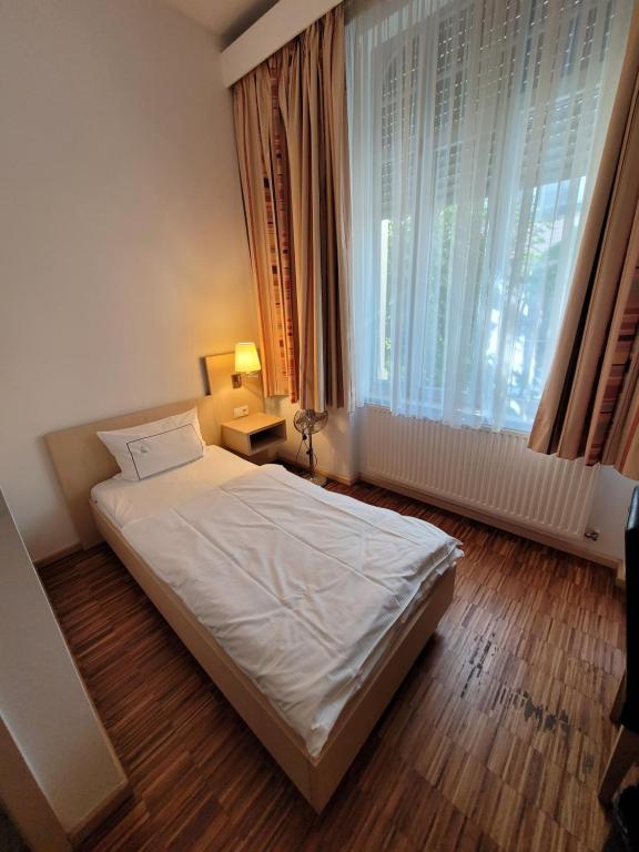 ein Schlafzimmer mit einem Bett und einem großen Fenster in der Unterkunft Apart1hotel in Luxemburg (Stadt)