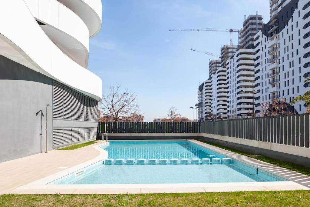 basen przed budynkiem z wysokimi budynkami w obiekcie Precioso apartamento en residencial con piscina w Walencji