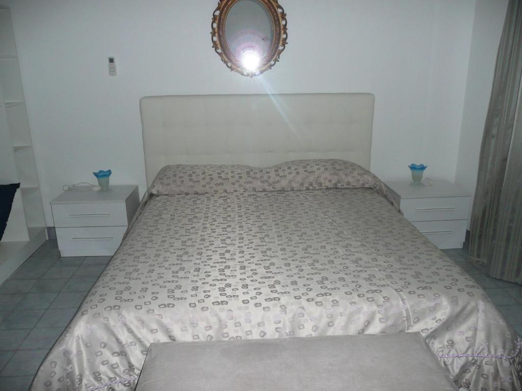 エルコラーノにあるGarden House Ercolanoのベッドルーム1室(壁に鏡が付いた白いベッド1台付)