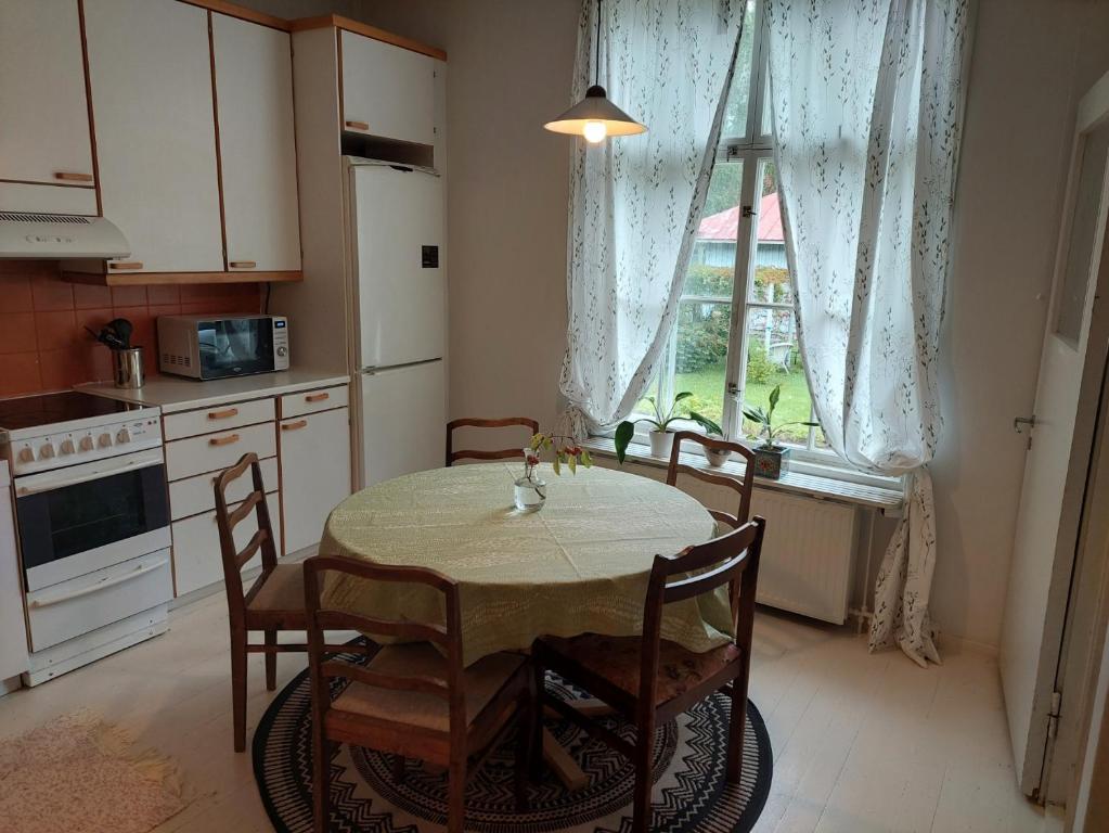 een keuken met een tafel en stoelen en een raam bij Nostalginen residenssi Taika in Varkaus