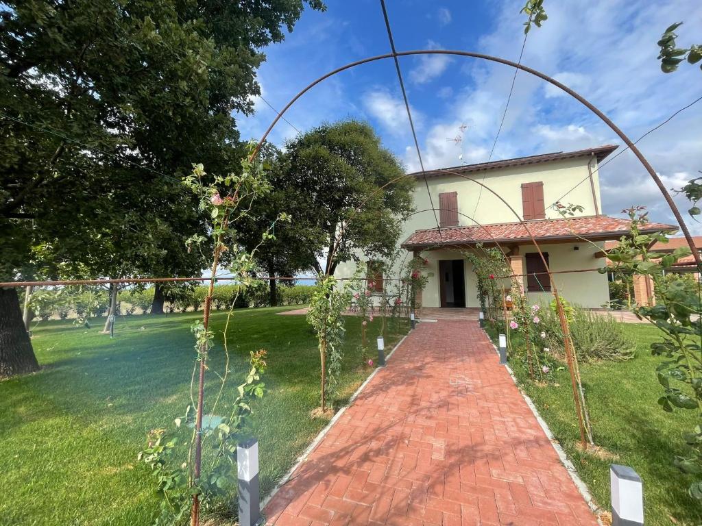 a house with a brick walkway in front of a yard at AFFITTACAMERE SAN MAMANTE in Santa Lucia delle Spianate