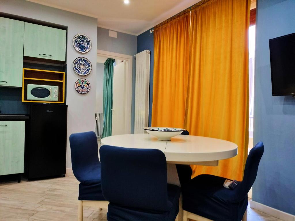 a kitchen with a white table and blue chairs at La casa dei ricordi in Cagliari