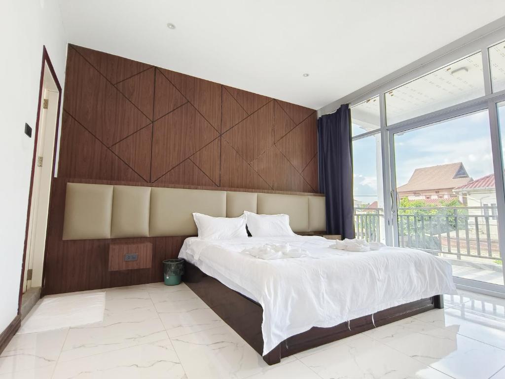 a bedroom with a large bed and a large window at Jenny airport lounge in Vientiane