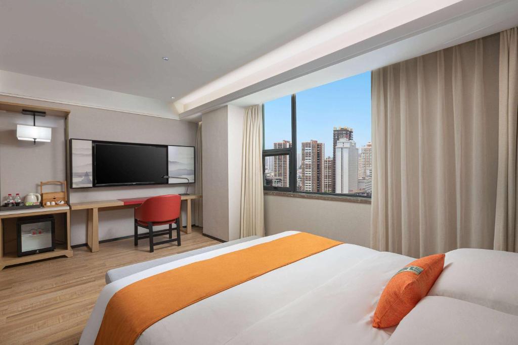 una camera d'albergo con un letto e una grande finestra di Hawthorn by Wyndham Dali Erhai Park a Dali