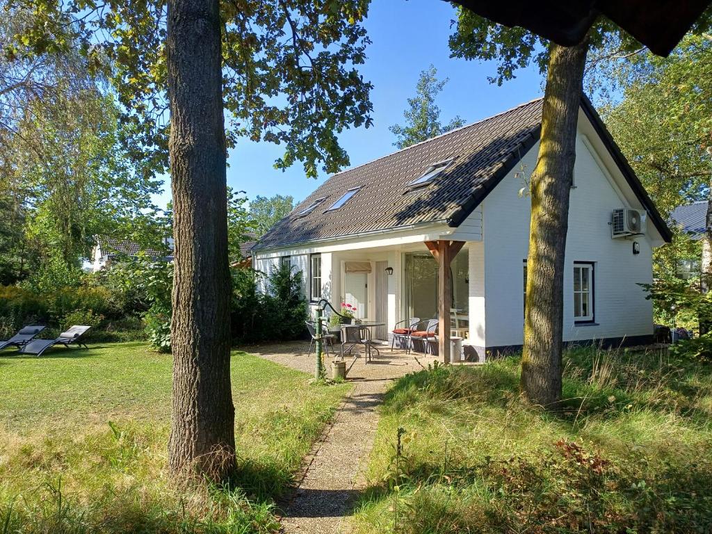 uma casa branca com árvores em frente em B&B Het mooie uitzicht em Reuver