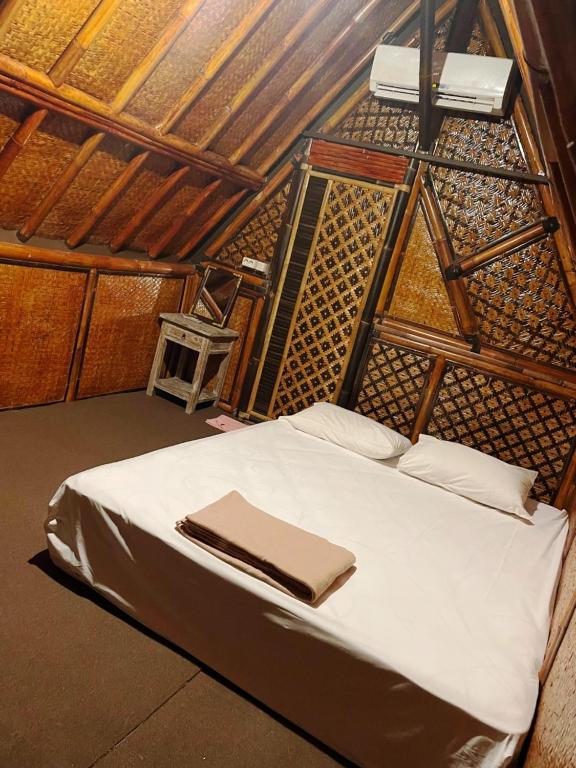 Un pat sau paturi într-o cameră la Da Housetel Kuta