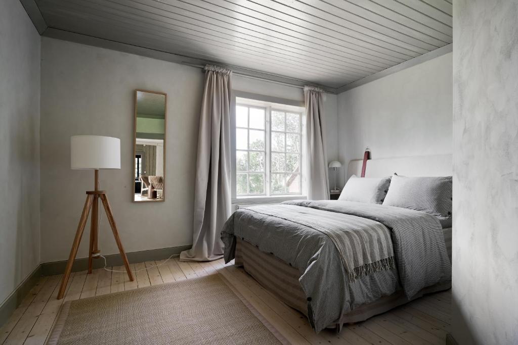 una camera con un grande letto e una finestra di Kungs Starby Gård Bed and Breakfast a Vadstena