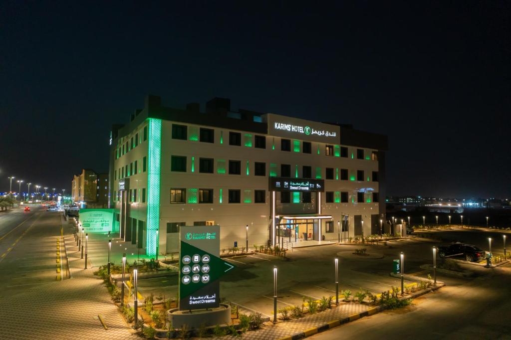 um edifício com uma placa à frente à noite em Karims Hotel em Al Majmaah