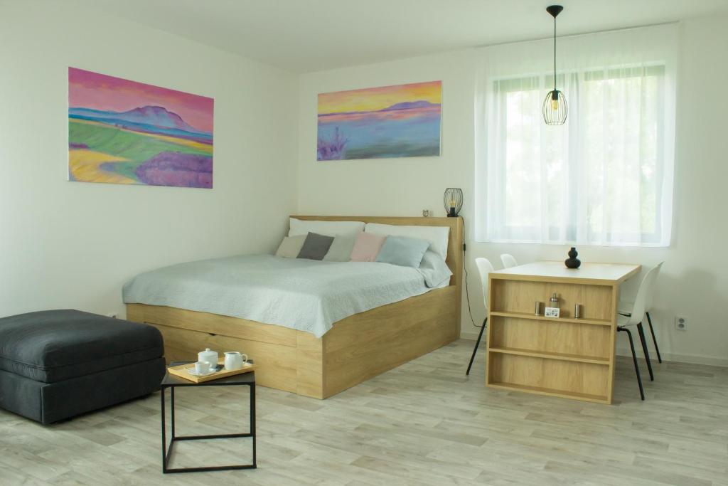 a bedroom with a bed and a chair and a table at Apartmán X28 in Mikulov
