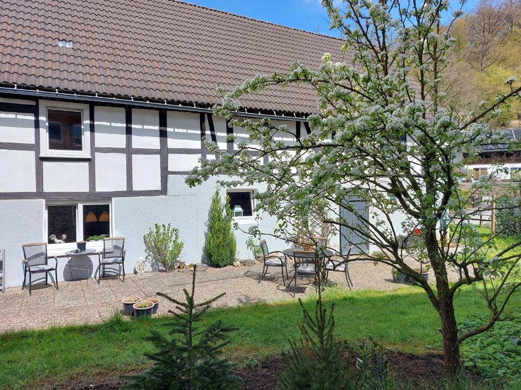 una casa blanca con una mesa y sillas en un patio en Haus am Bach, en Hallenberg