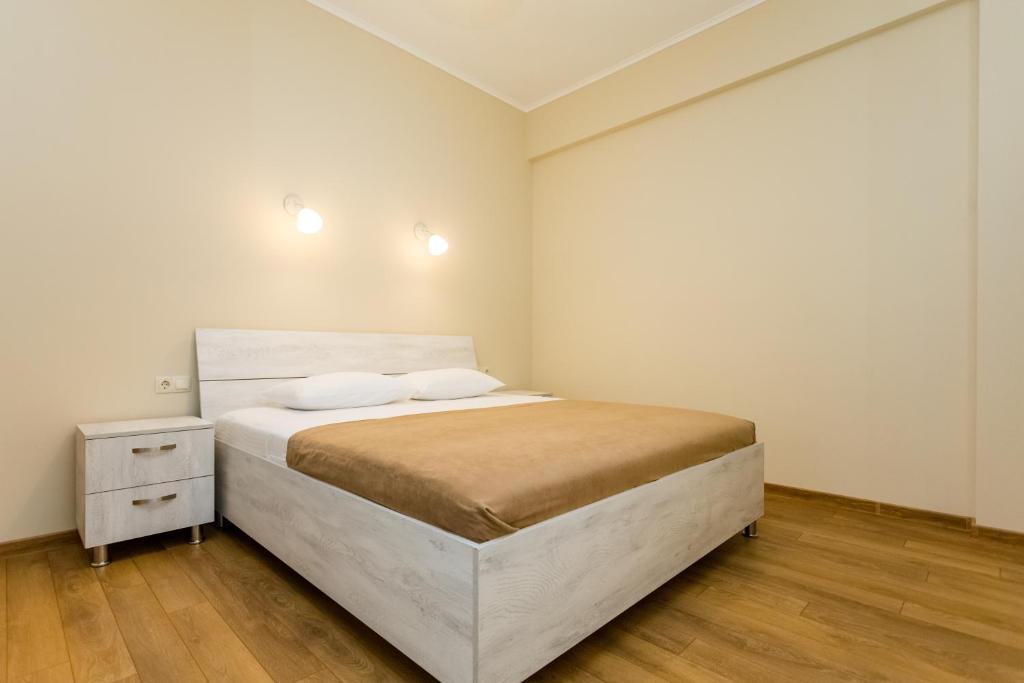 - une chambre blanche avec un lit et une table de nuit dans l'établissement Comfy Home V, à Tbilissi