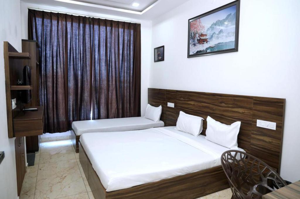 a hotel room with a bed and a window at Hotel Homeland Inn in Sirsa