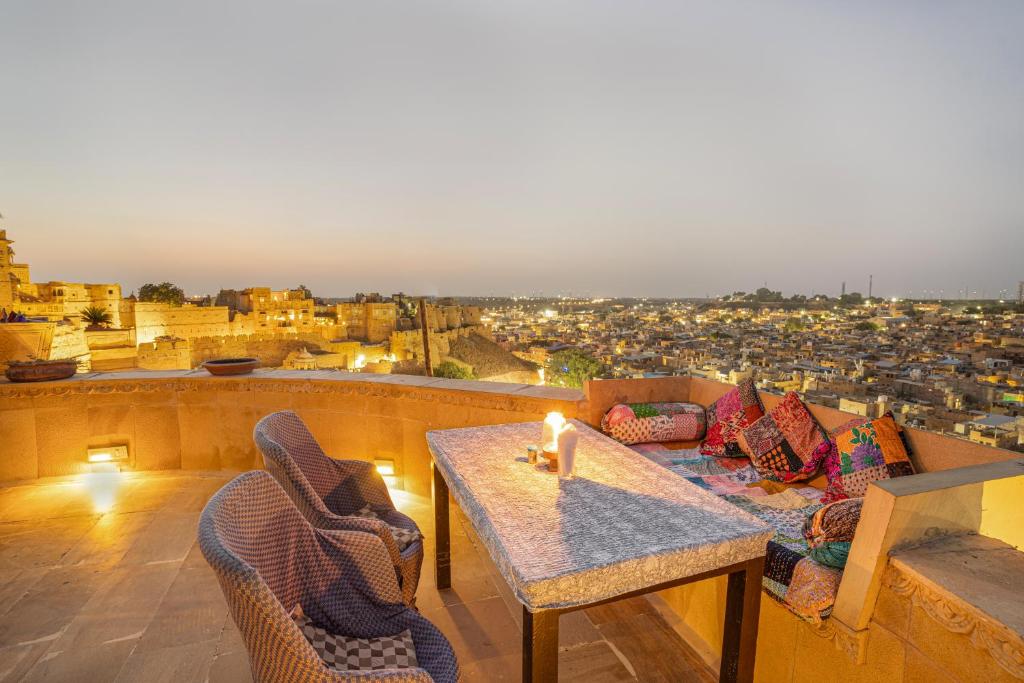 a table and chairs on a balcony with a view at Hotel Garh Jaisal Haveli in Jaisalmer