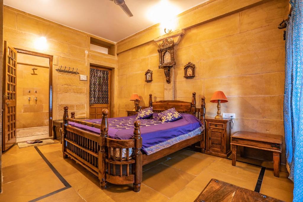 a bedroom with a bed and a wooden wall at Hotel Garh Jaisal Haveli in Jaisalmer