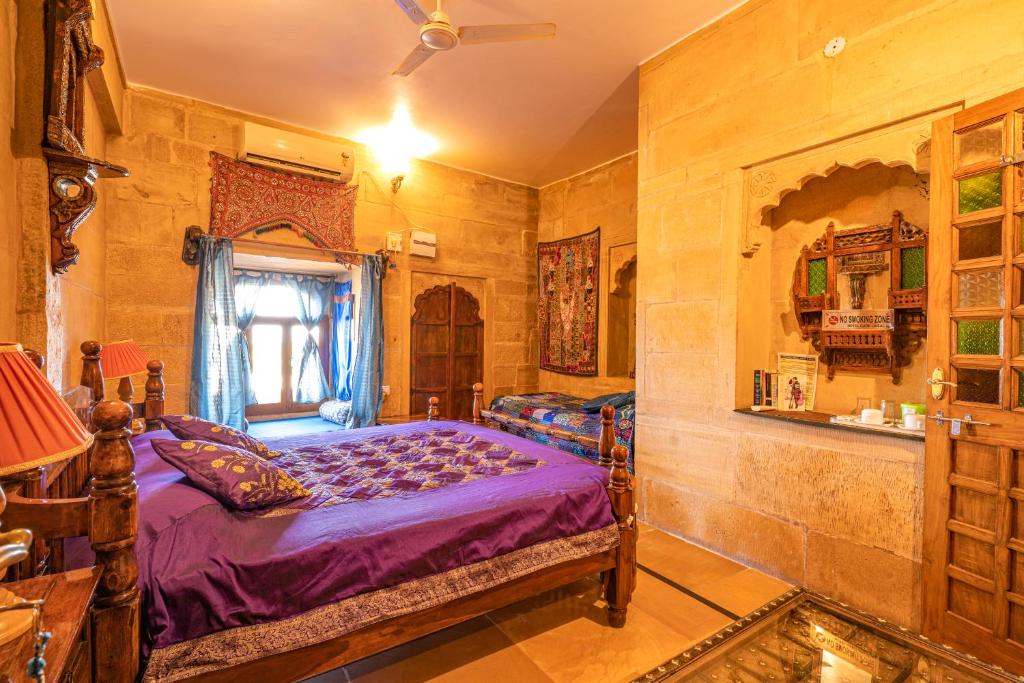 a bedroom with a bed and a window at Hotel Garh Jaisal Haveli in Jaisalmer