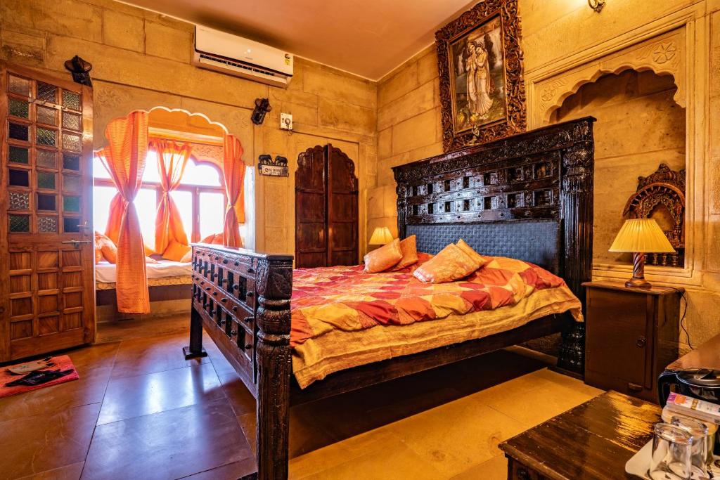 a bedroom with a large wooden bed in a room at Hotel Garh Jaisal Haveli in Jaisalmer