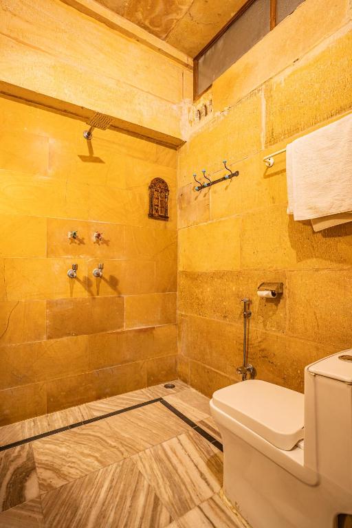 a bathroom with a toilet and a yellow wall at Hotel Garh Jaisal Haveli in Jaisalmer